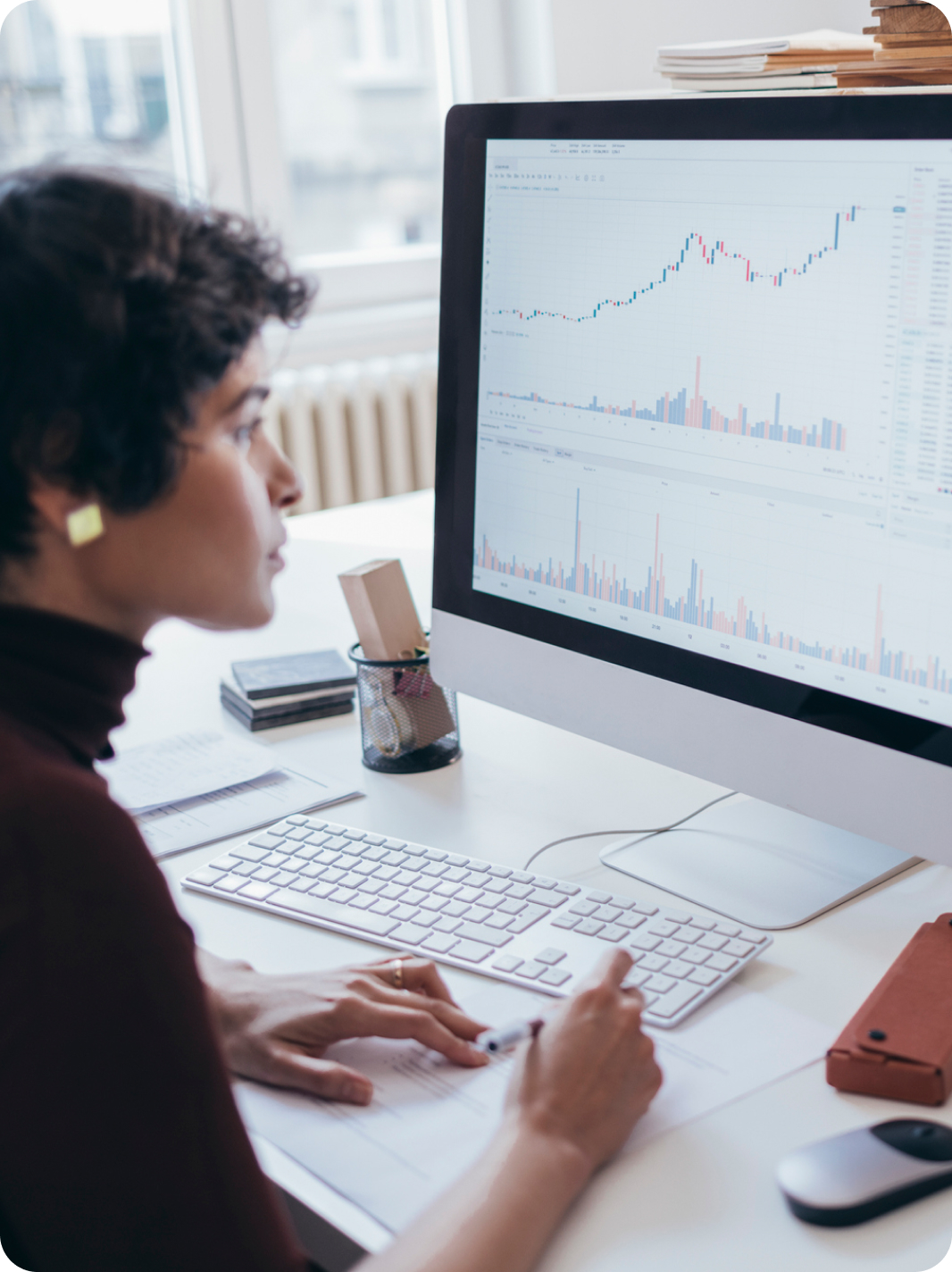 Woman staring at graphs on computer screen